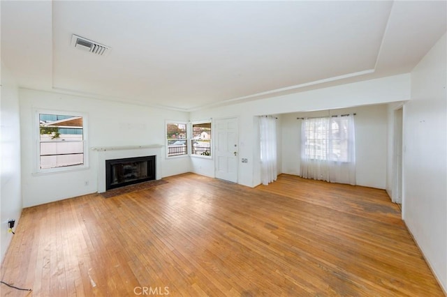 unfurnished living room featuring plenty of natural light and hardwood / wood-style floors