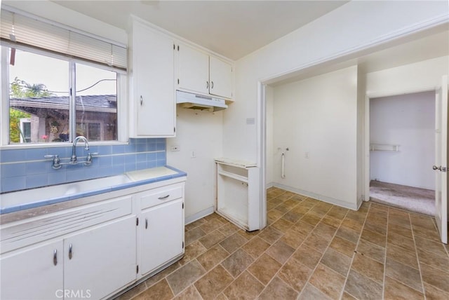 kitchen with white cabinetry, sink, and tasteful backsplash