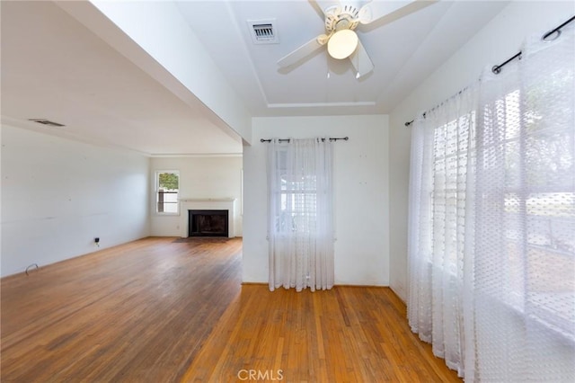 unfurnished living room featuring hardwood / wood-style flooring and ceiling fan