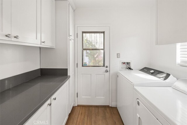 laundry room with cabinets, dark hardwood / wood-style floors, and washer and clothes dryer