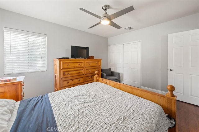 bedroom with ceiling fan, dark hardwood / wood-style flooring, and a closet