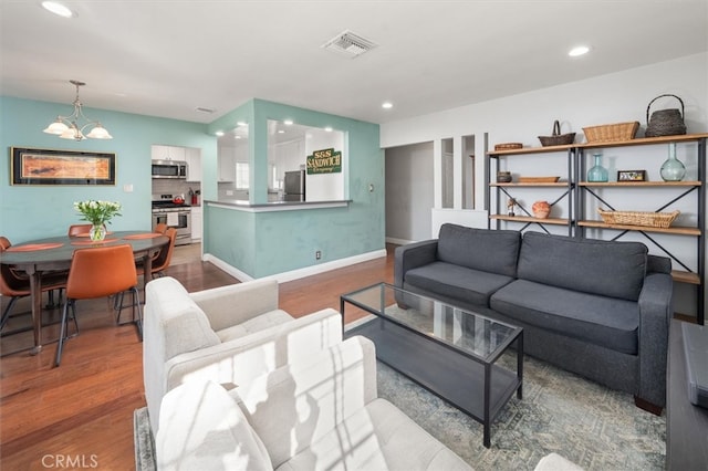 living room with hardwood / wood-style flooring and a chandelier