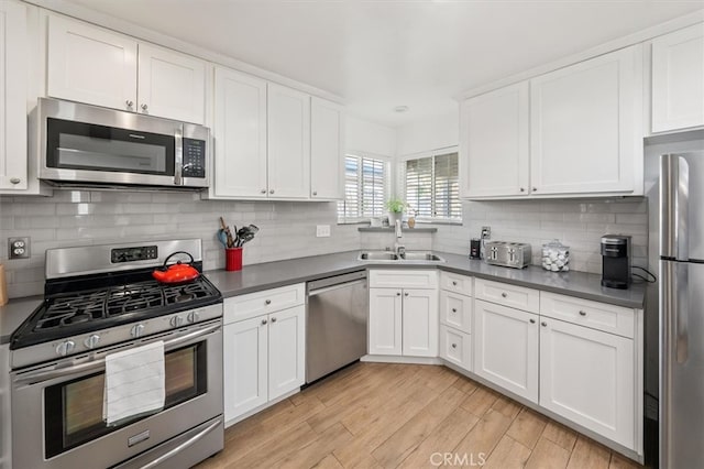 kitchen featuring appliances with stainless steel finishes, sink, and white cabinets