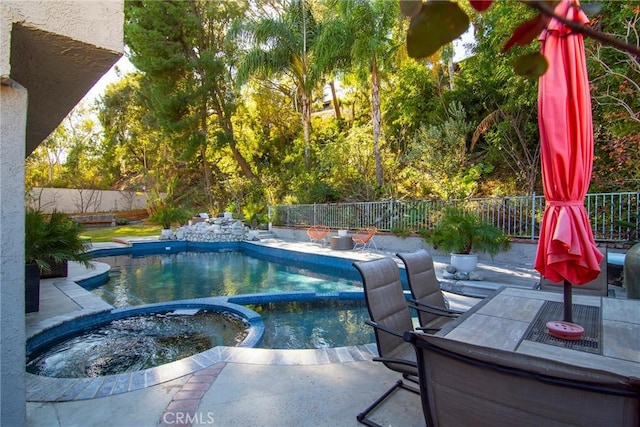 view of swimming pool featuring an in ground hot tub and a patio area