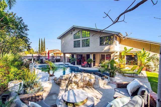 back of house with an outdoor living space and a patio