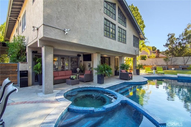 rear view of property with a patio, outdoor lounge area, and a pool with hot tub