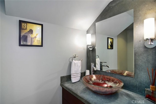 bathroom with vanity and lofted ceiling