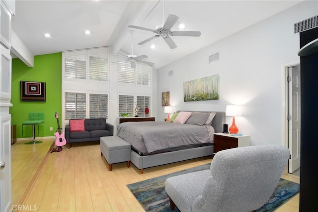 bedroom featuring beam ceiling, light hardwood / wood-style flooring, high vaulted ceiling, and ceiling fan