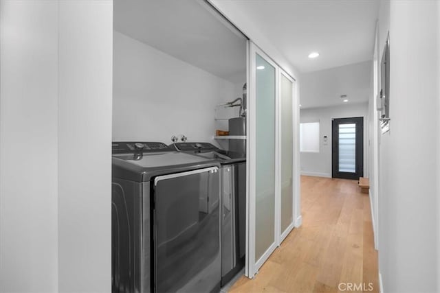 washroom featuring washer and clothes dryer and light hardwood / wood-style floors