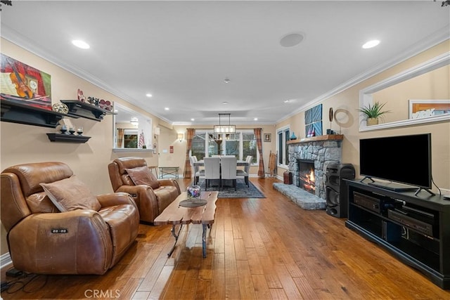 living room with wood-type flooring, a fireplace, and crown molding