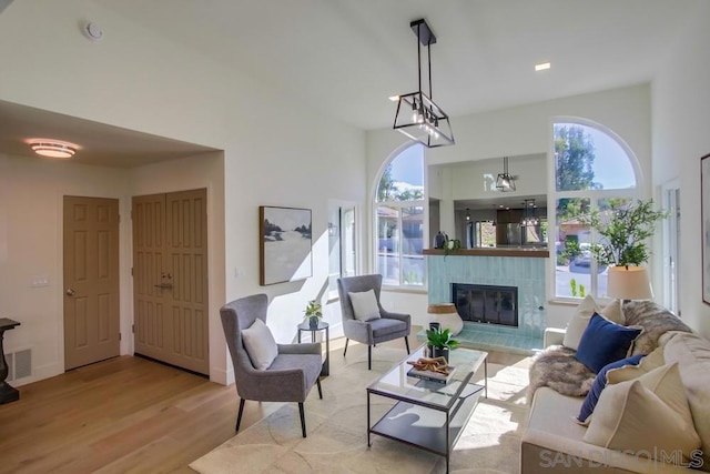 living room with a tile fireplace and light wood-type flooring