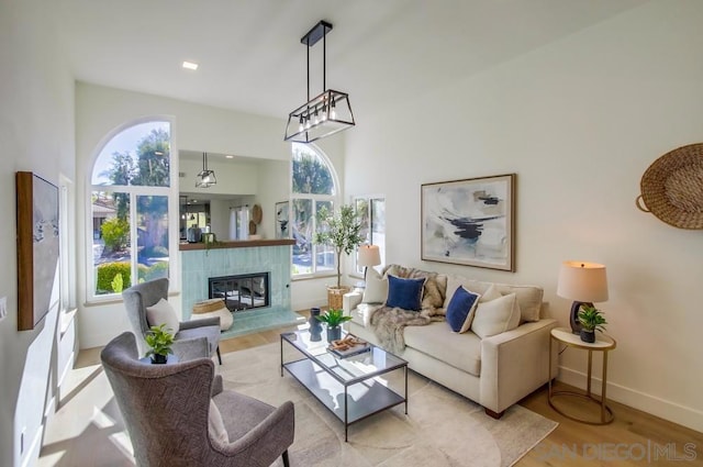 living room featuring a tile fireplace and light wood-type flooring