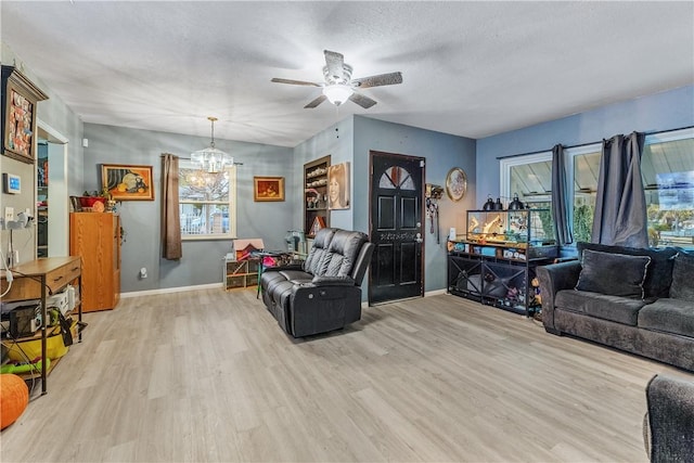 living room with a notable chandelier, a textured ceiling, and light wood-type flooring