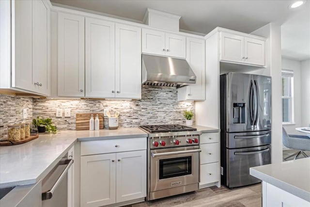 kitchen featuring backsplash, light hardwood / wood-style flooring, stainless steel appliances, and white cabinets