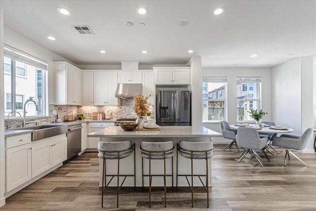 kitchen with white cabinetry, appliances with stainless steel finishes, a center island, and sink