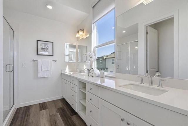 bathroom featuring hardwood / wood-style flooring, vanity, and a shower with door