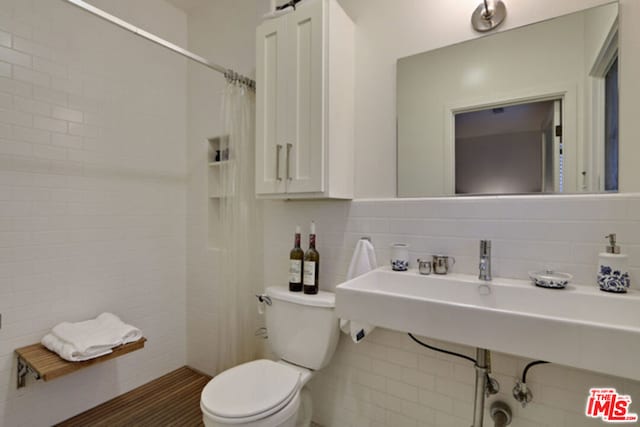 bathroom with tile walls, backsplash, and toilet