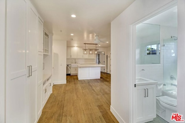 hallway with sink and light hardwood / wood-style floors