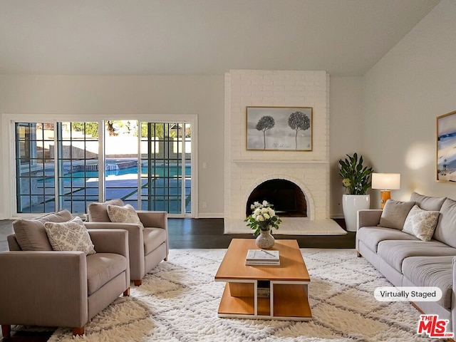 living room featuring a brick fireplace and hardwood / wood-style floors