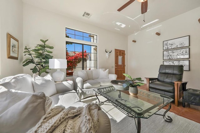 living room with ceiling fan and a high ceiling