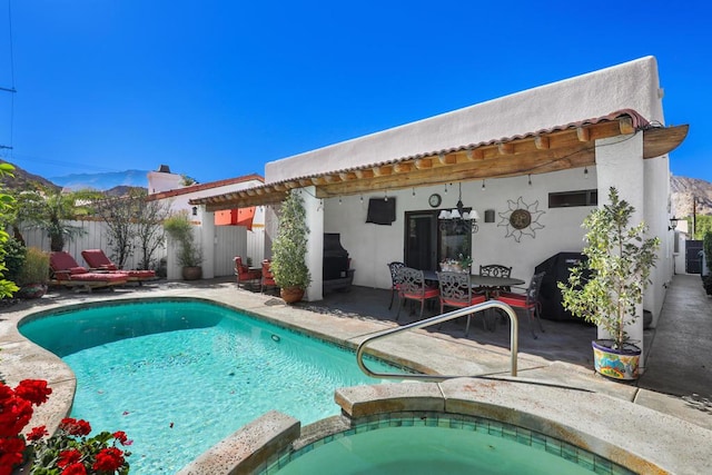 view of pool with a mountain view, a patio, and an in ground hot tub