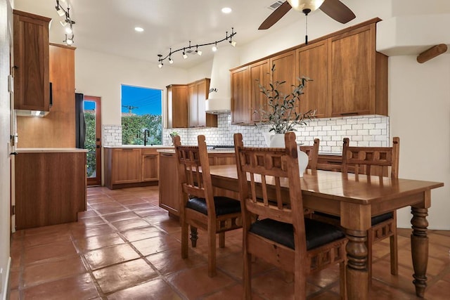 kitchen with ceiling fan, custom range hood, sink, and decorative backsplash