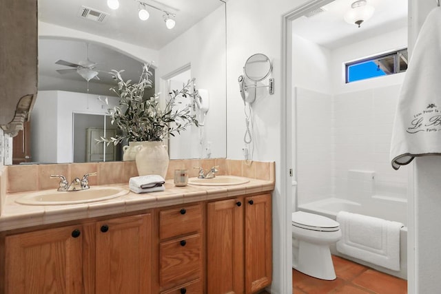 full bathroom with washtub / shower combination, toilet, vanity, ceiling fan, and tile patterned flooring