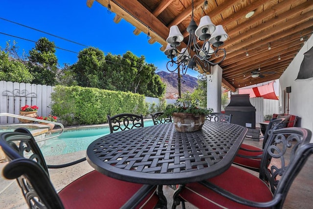 view of patio with a fenced in pool, a mountain view, and ceiling fan