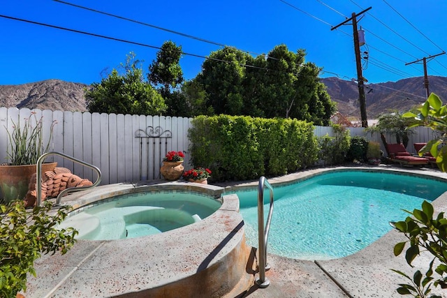 view of pool with an in ground hot tub and a mountain view