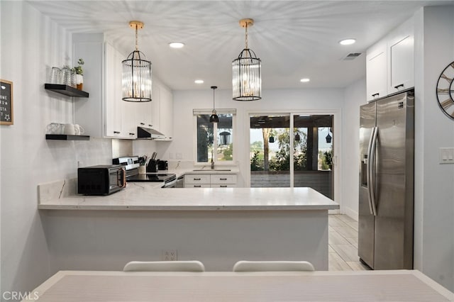 kitchen with appliances with stainless steel finishes, light stone countertops, white cabinets, decorative light fixtures, and kitchen peninsula