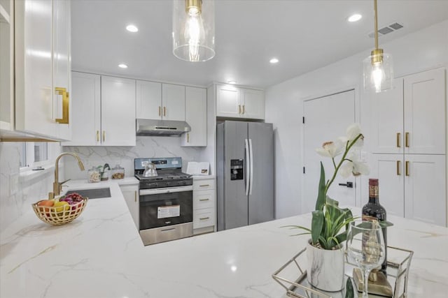 kitchen featuring appliances with stainless steel finishes, pendant lighting, white cabinetry, sink, and light stone countertops