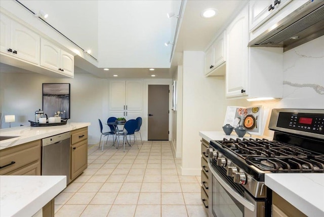 kitchen with light tile patterned floors, stainless steel appliances, and white cabinets