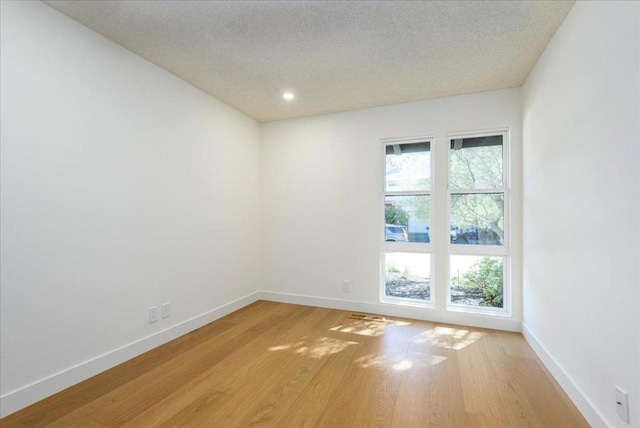 empty room featuring light hardwood / wood-style flooring and a textured ceiling