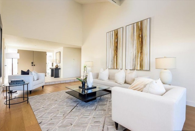 living room with hardwood / wood-style flooring and a towering ceiling