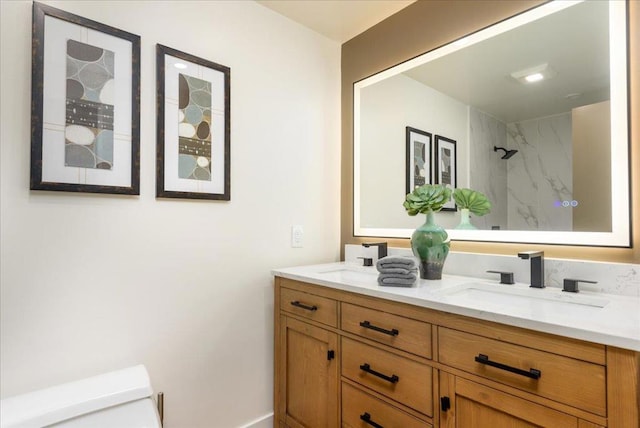 bathroom with vanity, tiled shower, and toilet