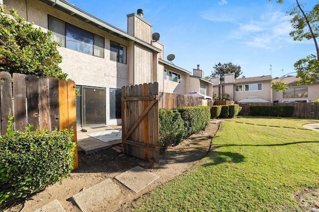 rear view of house featuring a yard