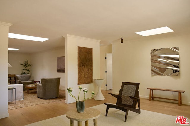 sitting room featuring crown molding and light hardwood / wood-style flooring