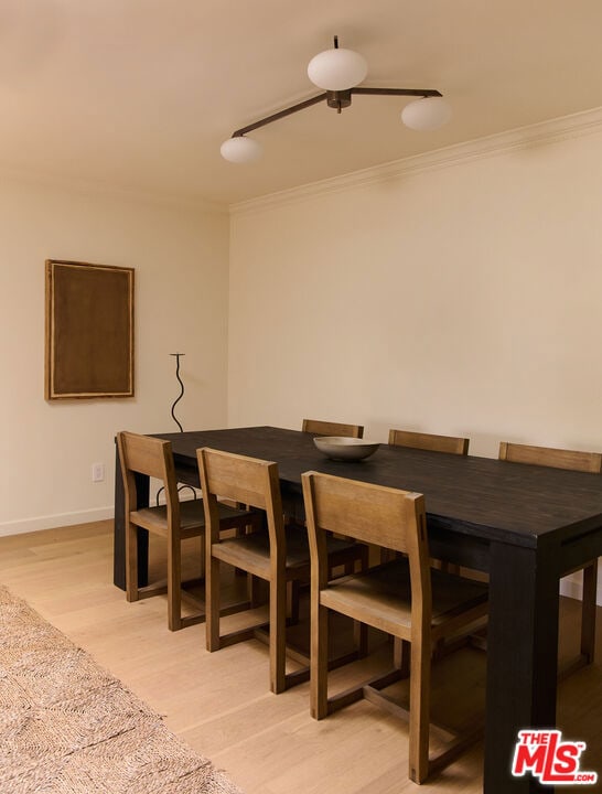 dining area featuring crown molding and light hardwood / wood-style flooring