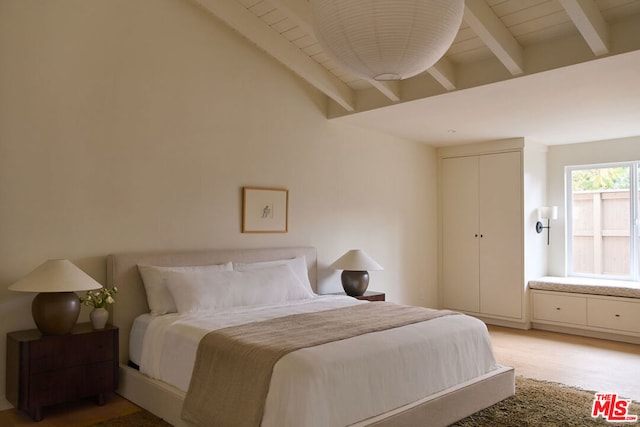 bedroom featuring lofted ceiling with beams