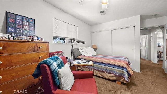 bedroom with a closet, ceiling fan, and carpet flooring