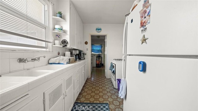 kitchen featuring sink, white cabinetry, tasteful backsplash, tile counters, and white appliances