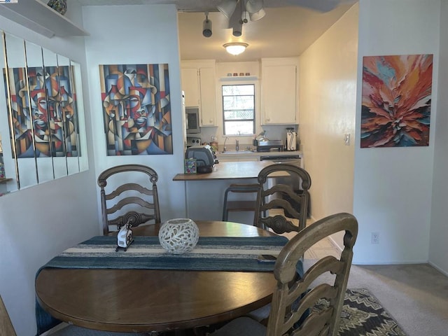 dining space featuring carpet floors and sink