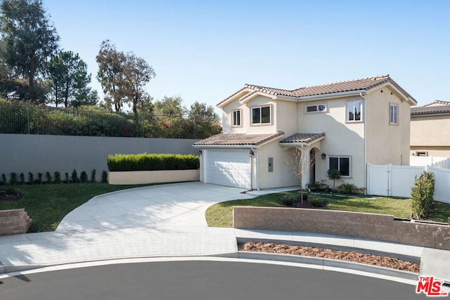 mediterranean / spanish house with a garage and a front yard