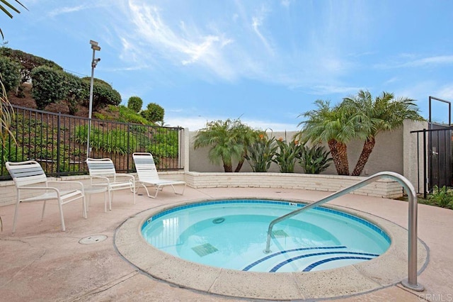 view of swimming pool with a community hot tub and a patio area