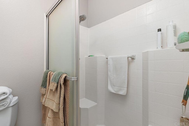 bathroom with toilet and an enclosed shower