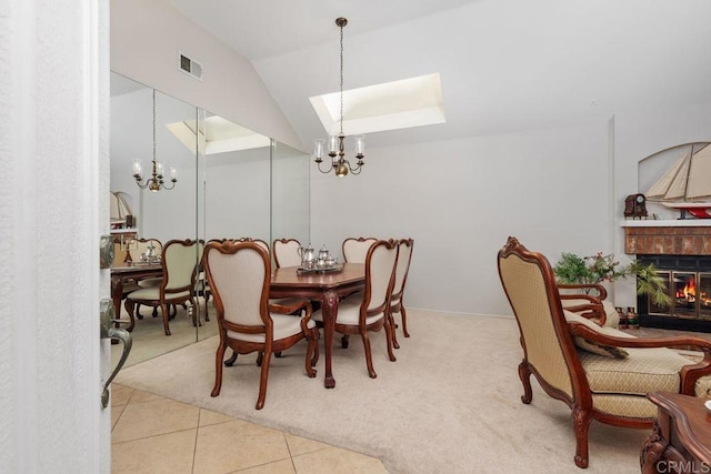 dining area featuring lofted ceiling, a fireplace, light tile patterned floors, and a notable chandelier