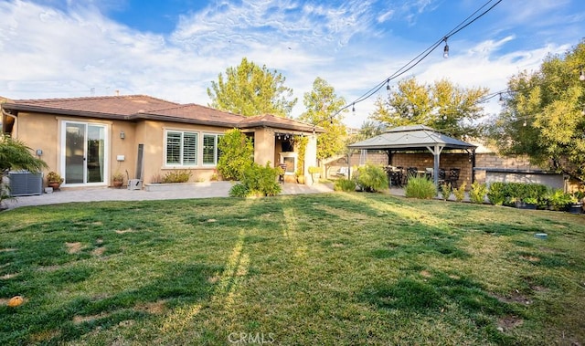 rear view of property with a gazebo, a lawn, central AC unit, and a patio area