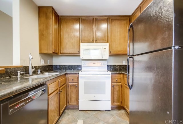 kitchen with sink, black appliances, dark stone counters, and light tile patterned flooring