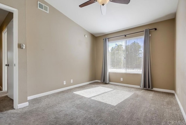 empty room featuring light carpet, vaulted ceiling, and ceiling fan