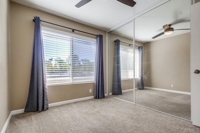 unfurnished bedroom with light carpet, ceiling fan, and a closet